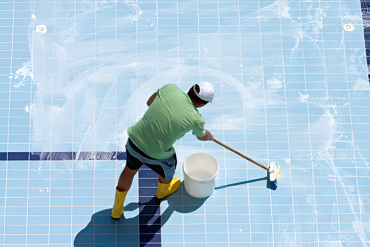 A professional washing a pool