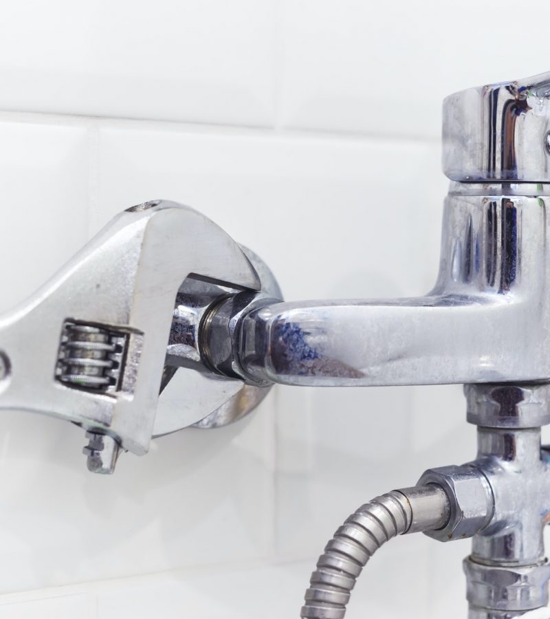 plumber-uses-pipe-wrench-for-service-shower-mixer-tap.jpg